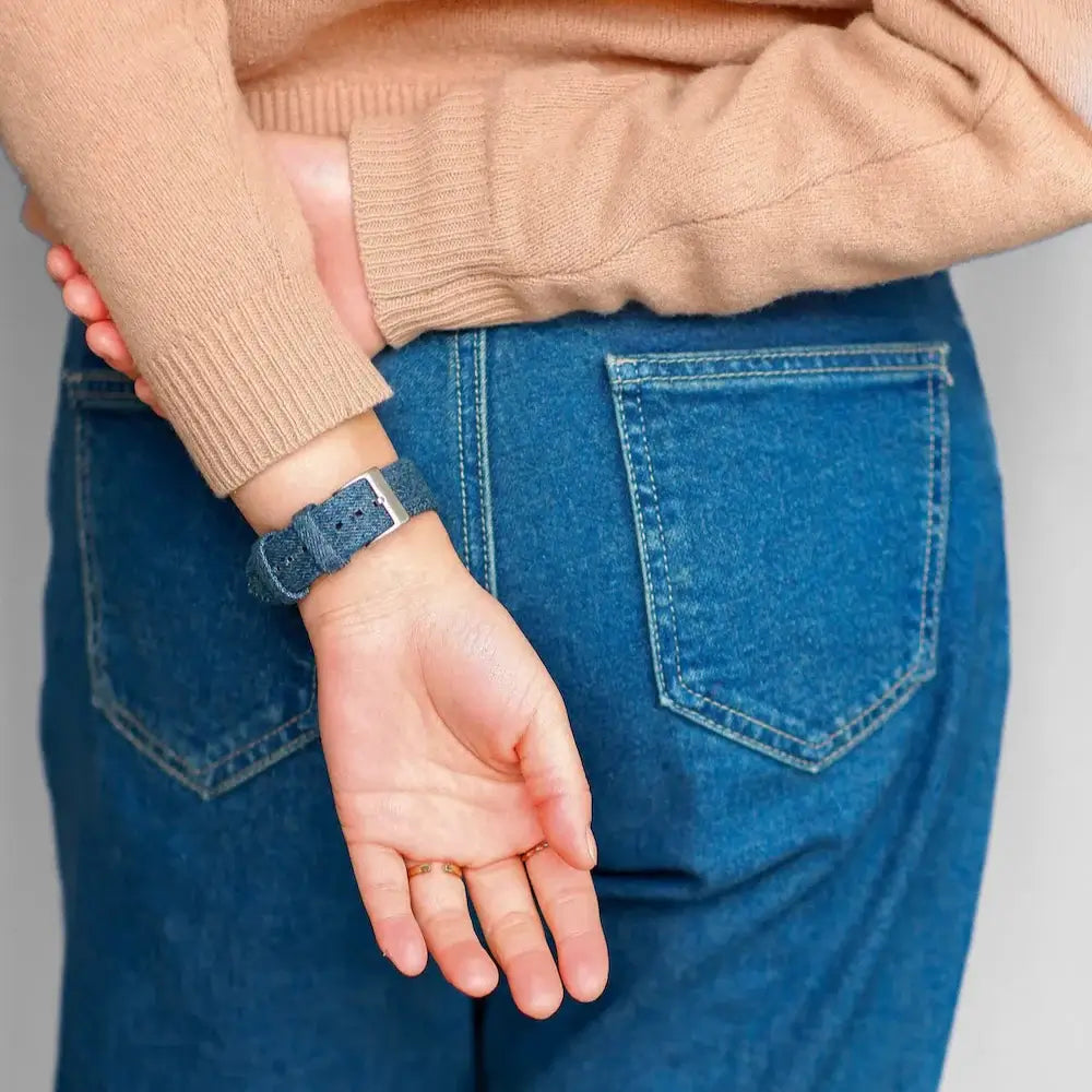 Person wearing Premium Jeans Apple Watch Band with Hochwertiger Denim and blue jeans back pocket view.
