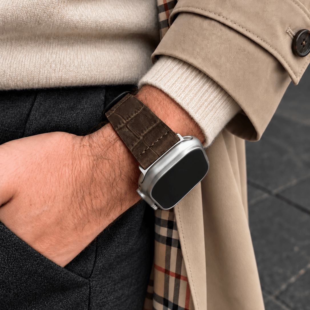 Dakkar Dunkelbraun – 24 mm Apple Watch Ultra Lederarmband in Kroko-Optik am Handgelenk eines Mannes.