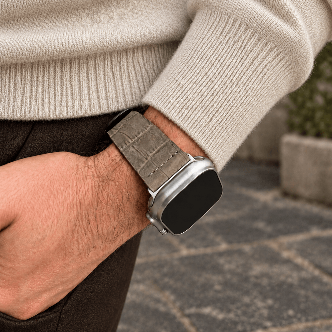 Dakkar Taubengrau – 24 mm Apple Watch Ultra Lederarmband in Kroko-Optik am Handgelenk eines Mannes.