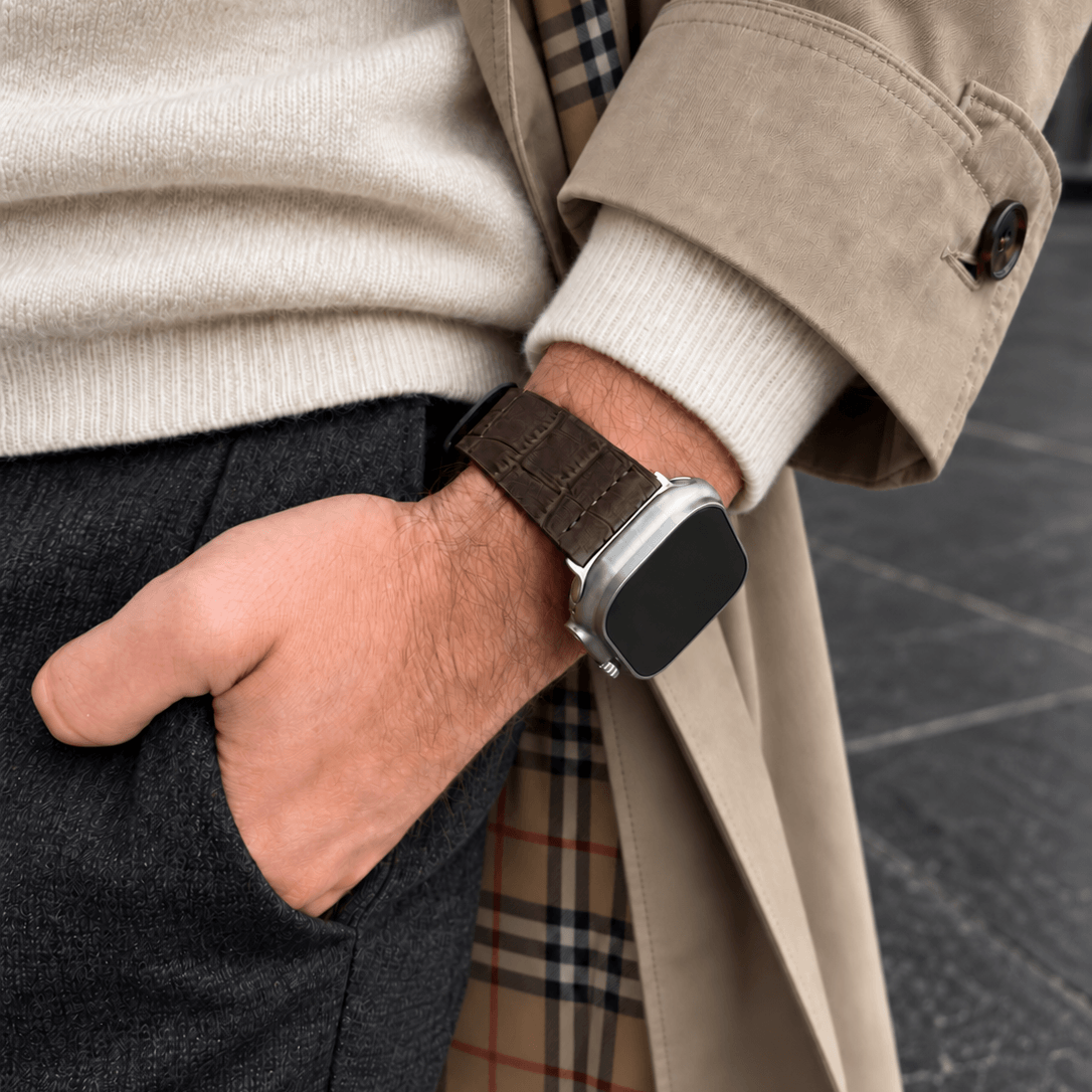 Dakkar Dunkelbraun – 24 mm Apple Watch Ultra Lederarmband in Kroko-Optik am Handgelenk einer Person.