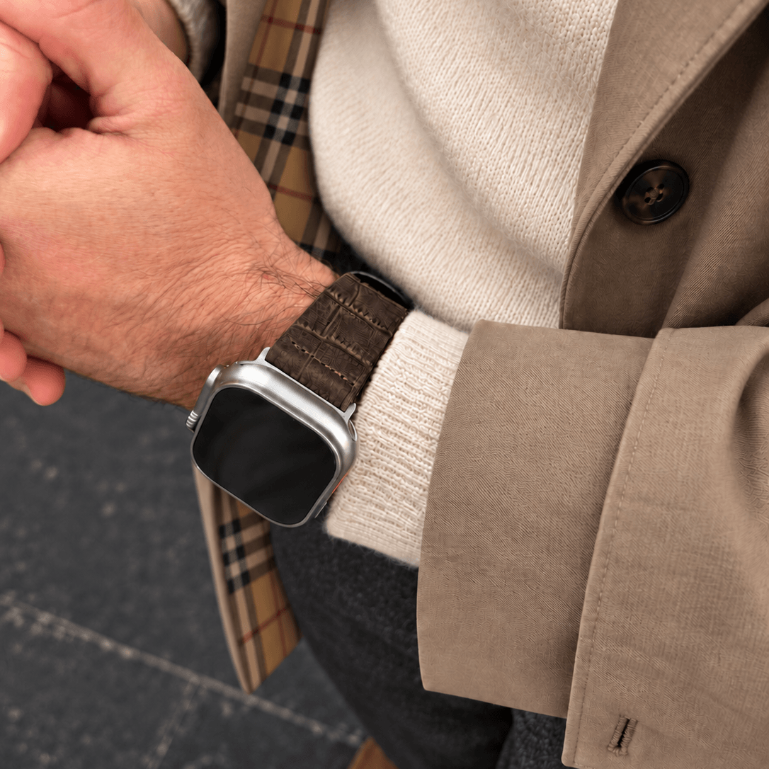 Dakkar Dunkelbraun – 24 mm Apple Watch Ultra Lederarmband in Kroko-Optik am Handgelenk eines Mannes.