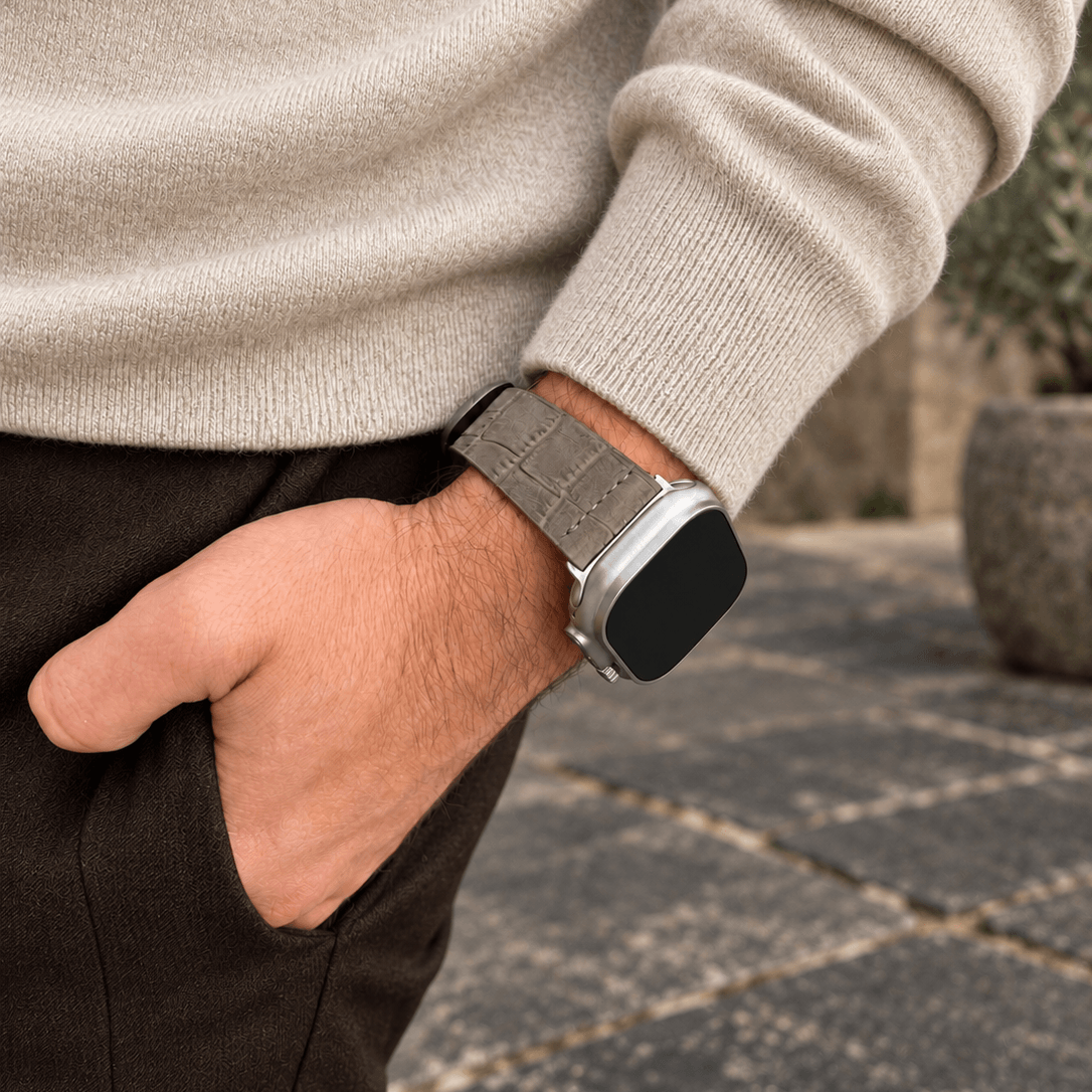 Dakkar Taubengrau – 24 mm Apple Watch Ultra Lederarmband in Kroko-Optik, an einem Handgelenk mit eleganter Kleidung.