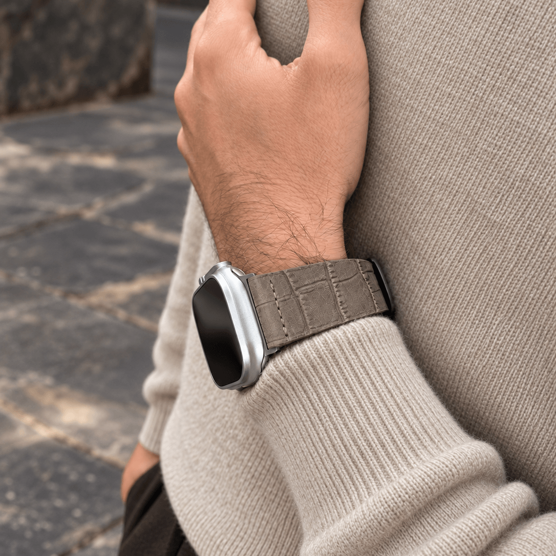Dakkar Taubengrau – 24 mm Apple Watch Ultra Lederarmband in Kroko-Optik am Handgelenk in stilvollem Ambiente.