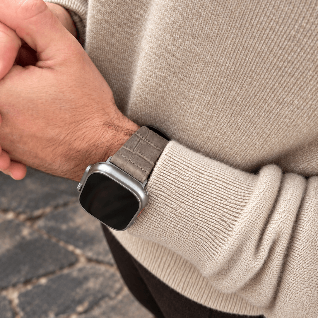 Dakkar Taubengrau – 24 mm Apple Watch Ultra Lederarmband in Kroko-Optik am Handgelenk eines Mannes.