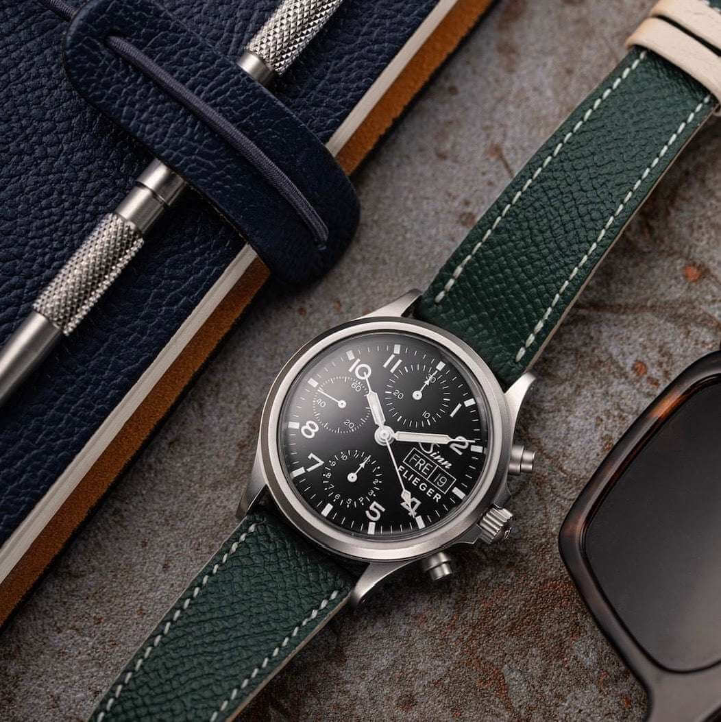 Dunkelgrünes Uhrenarmband aus hochwertigem Leder an Sinn Fliegeruhr – Detailaufnahme des Armbands an der ikonischen Uhr, sportliches Design, langlebig und Made in Germany