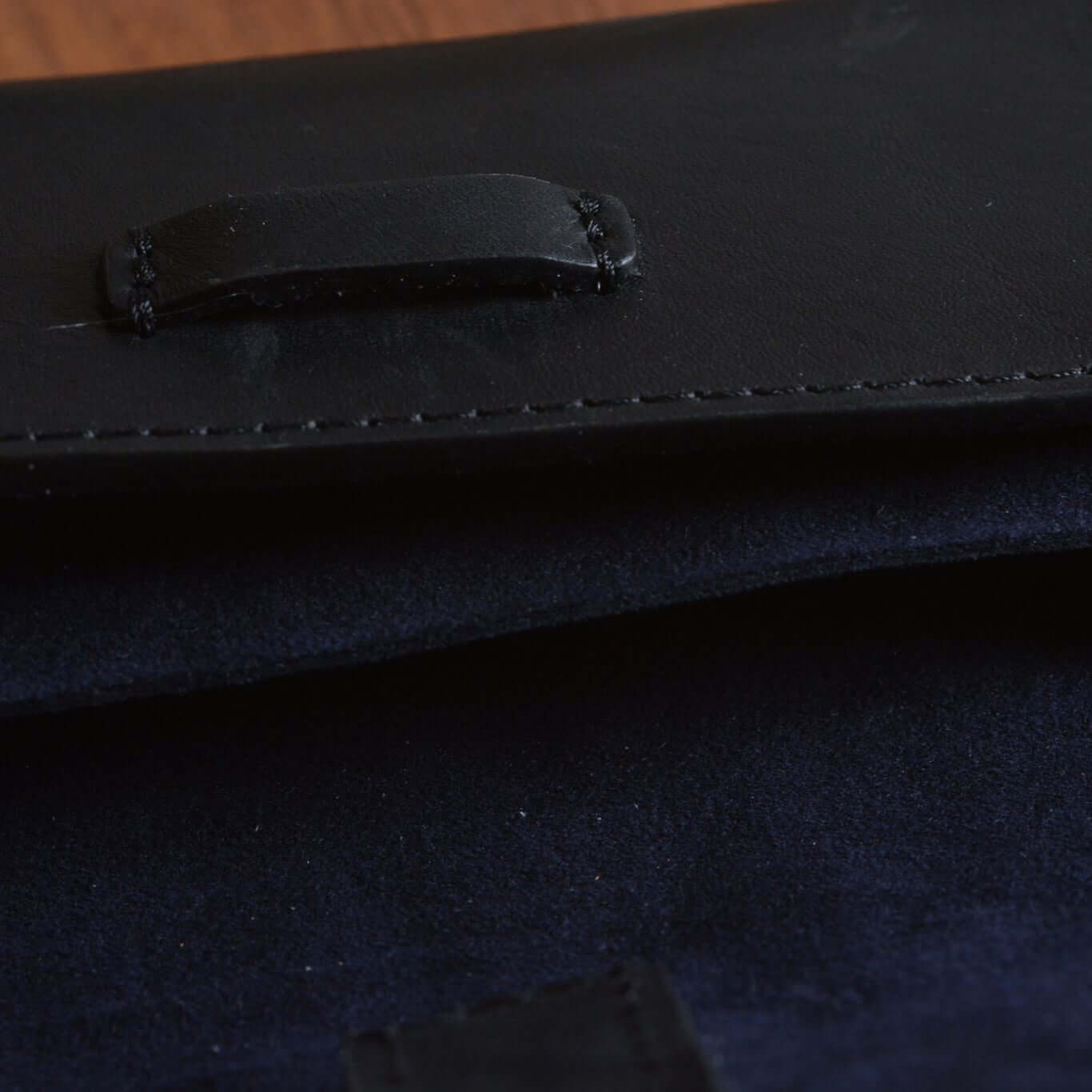 Close-up of a black leather FLUCO x The Urban Gentry Pocket Watch Case showing stitching details and texture.