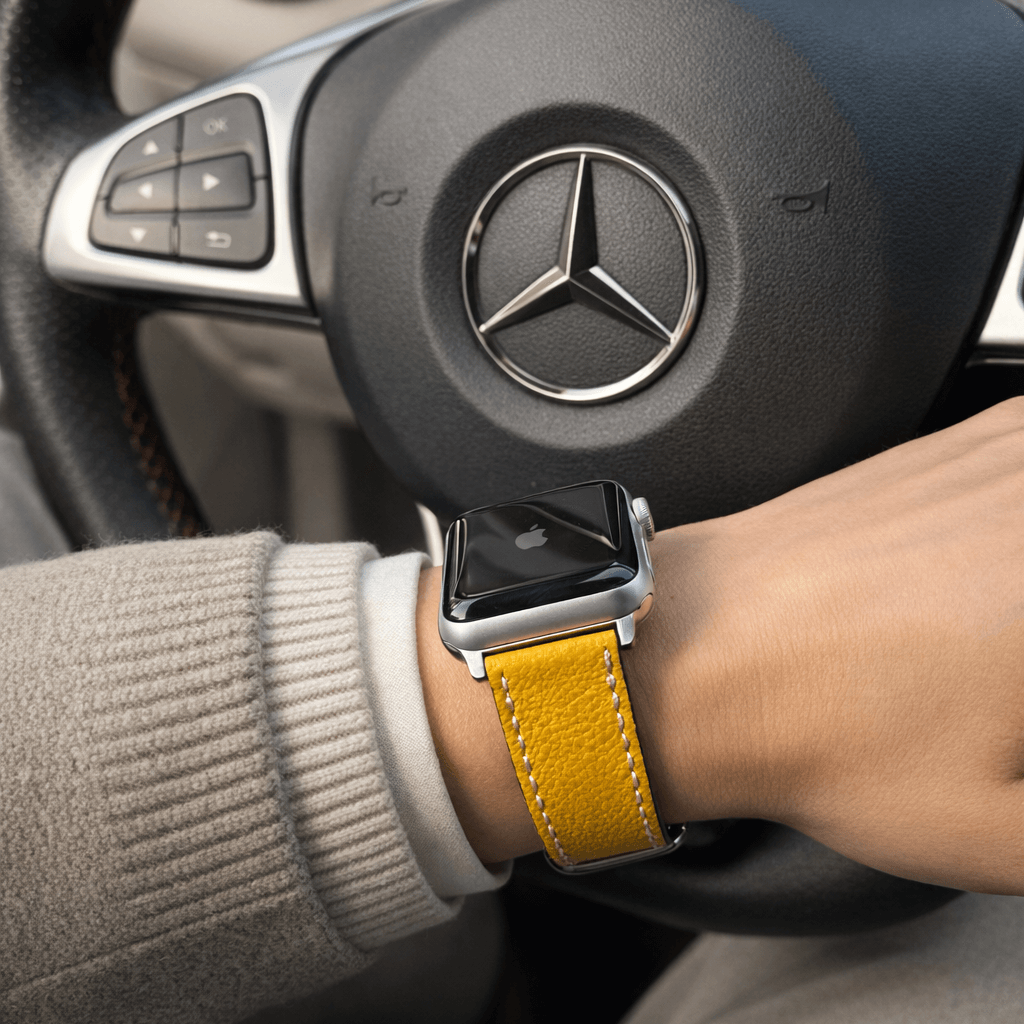 Luxuriöses Apple Watch Lederarmband Damen Cupertino Gelb am Handgelenk im Innenraum eines Autos.