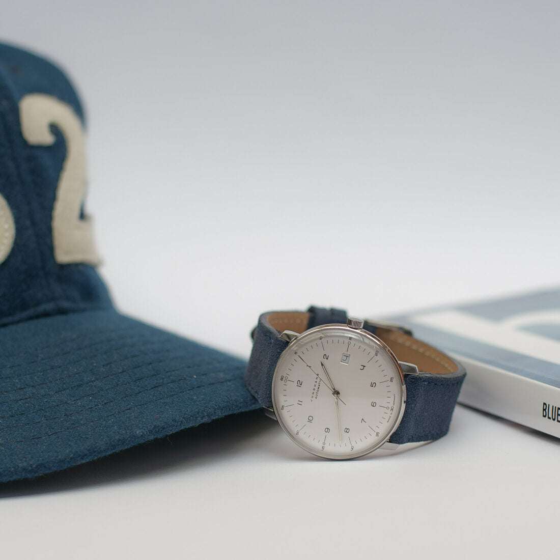 Marineblaues Nizza Velourslederarmband an einer Junghans Uhr, das die stilvolle Kombination von hochwertigem Leder und dem zeitlosen Design der Uhr hervorhebt.