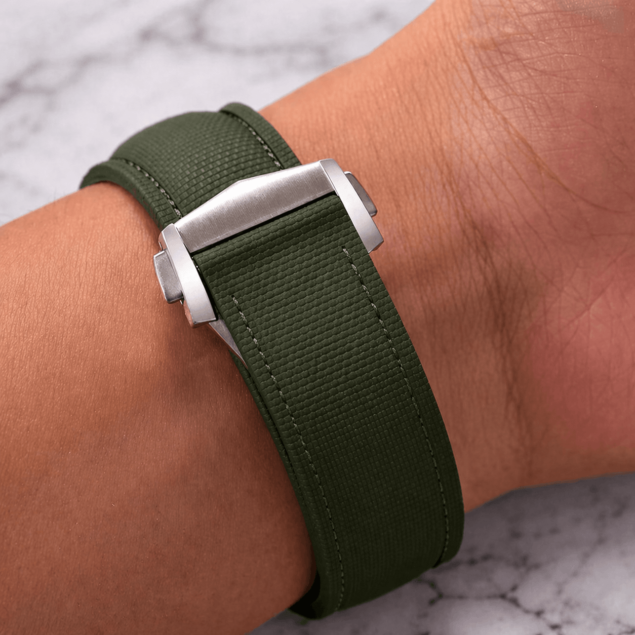 Monaco – Faltschließen Uhrenarmband aus FKM Kautschuk in grün mit Edelstahl-Faltschließe am Handgelenk.
