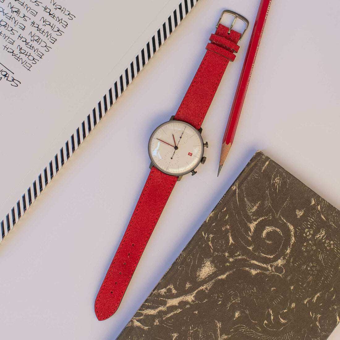 Rotes Nizza Velourslederarmband von oben an einer Junghans Uhr fotografiert, das die lebendige Farbnuance und die exzellente Verarbeitung des Uhrenarmbands betont.