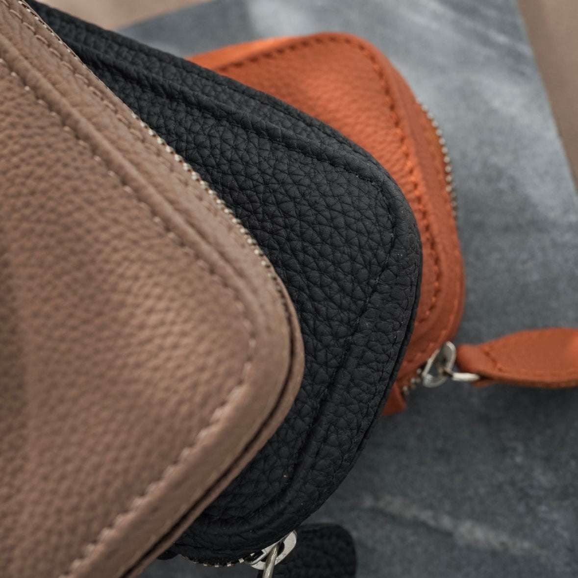 Seitenansicht von drei Uhrenetuis für zwei Uhren, aus hochwertigem Leder in verschiedenen Farben wie Cognac, Olivgrün und Beige. Ideal für die stilvolle und sichere Aufbewahrung von Luxusuhren, mit luxuriösem Innenfutter