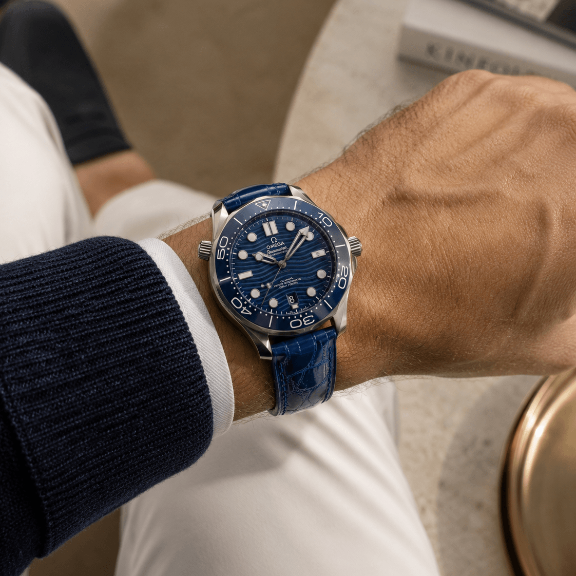 Shiny – Uhrenarmband aus glänzendem Kaimanleder an einer Omega Uhr mit blauem Zifferblatt.