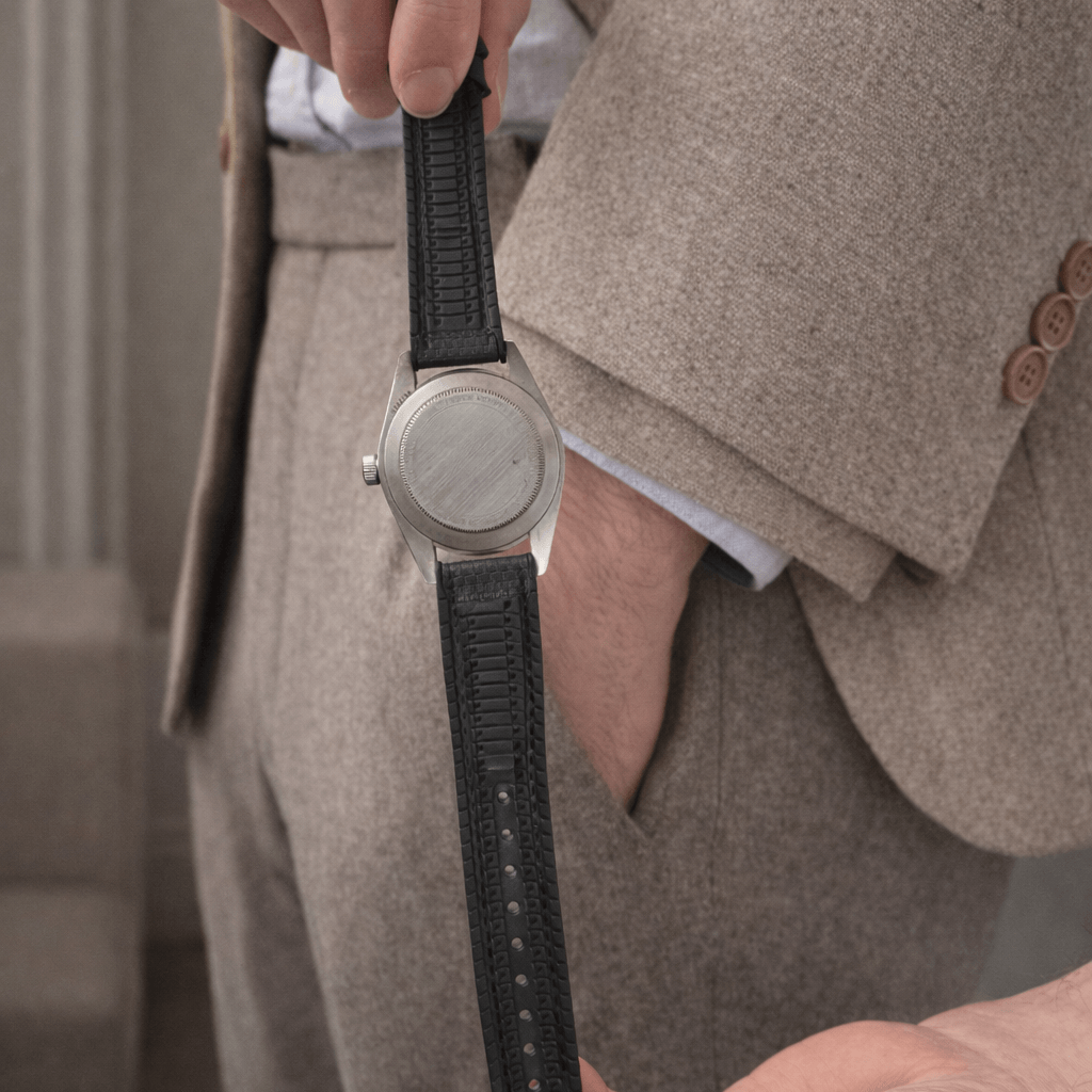 Person holding a watch with Triton – wasserfestes Performance-Uhrenarmband in a stylish setting.