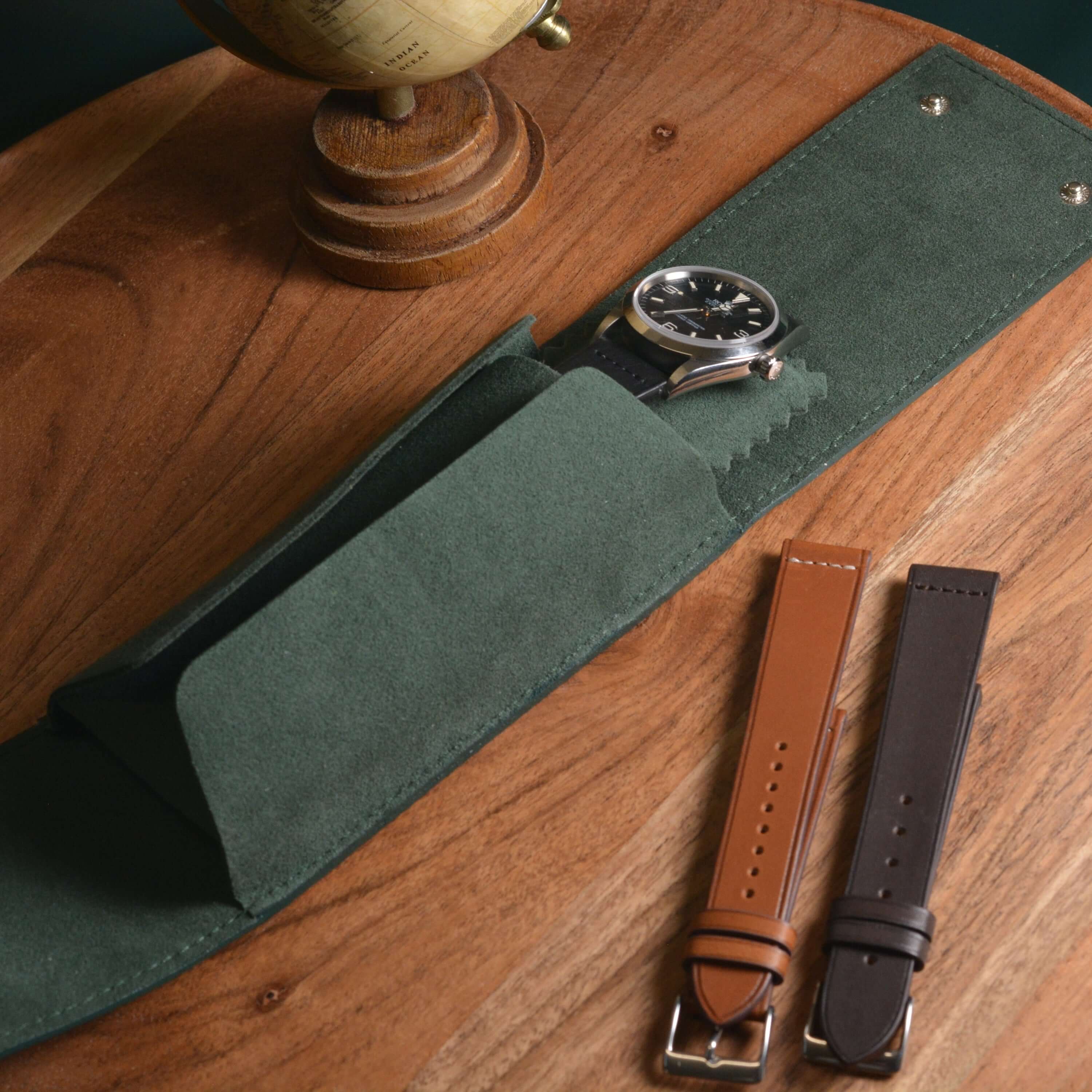 Offenes grünes Lederetui mit Alcantara-Innenfutter und eingelegter Rolex Oyster Perpetual – perfekte Uhrenaufbewahrung für Luxusuhren, sicher und stilvoll geschützt auf Reisen.