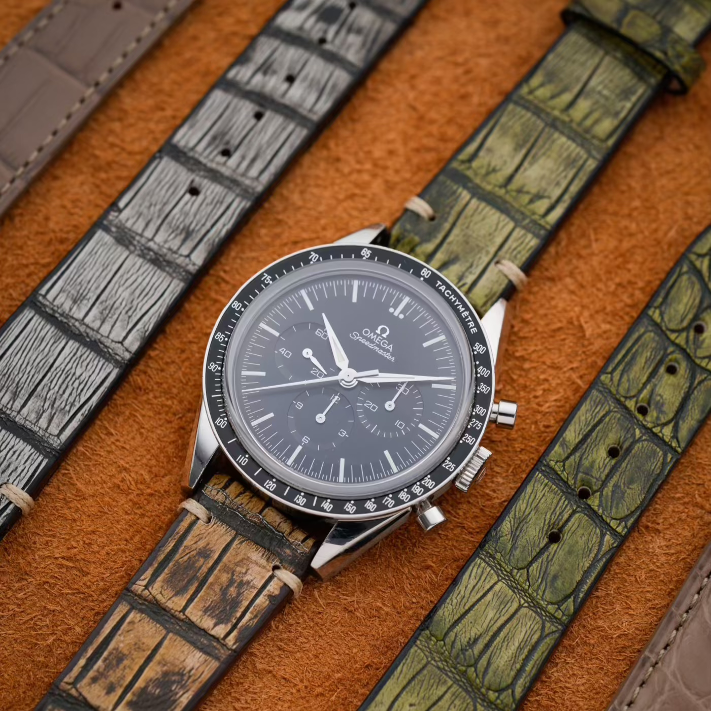 Nahaufnahme eines eleganten Vintage Alligator Uhrenarmbands, präsentiert neben weiteren Uhrenarmbändern auf einem samtigen Untergrund.