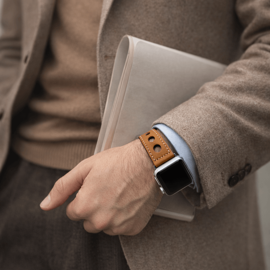 Mann trägt Cognac Rallye Apple Watch Lederarmband im Panerai-Stil, handgefertigt aus Kalbleder mit markanten Lochungen.