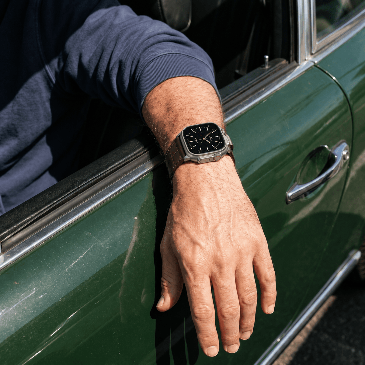 Dunkelbraunes Apple Watch Armband Louisiana Alligator Full Cut an einem Handgelenk, während er aus einem Auto schaut.