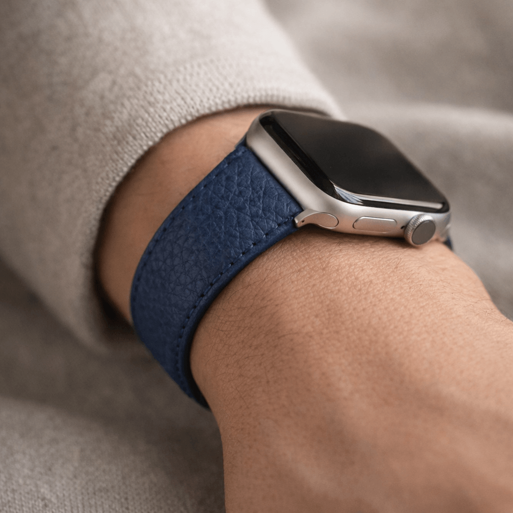 Nahaufnahme des Uhrenarmbands Apple Watch – Handgefertigtes Hirschleder in Blau, getragen am Handgelenk für stilvollen Komfort.