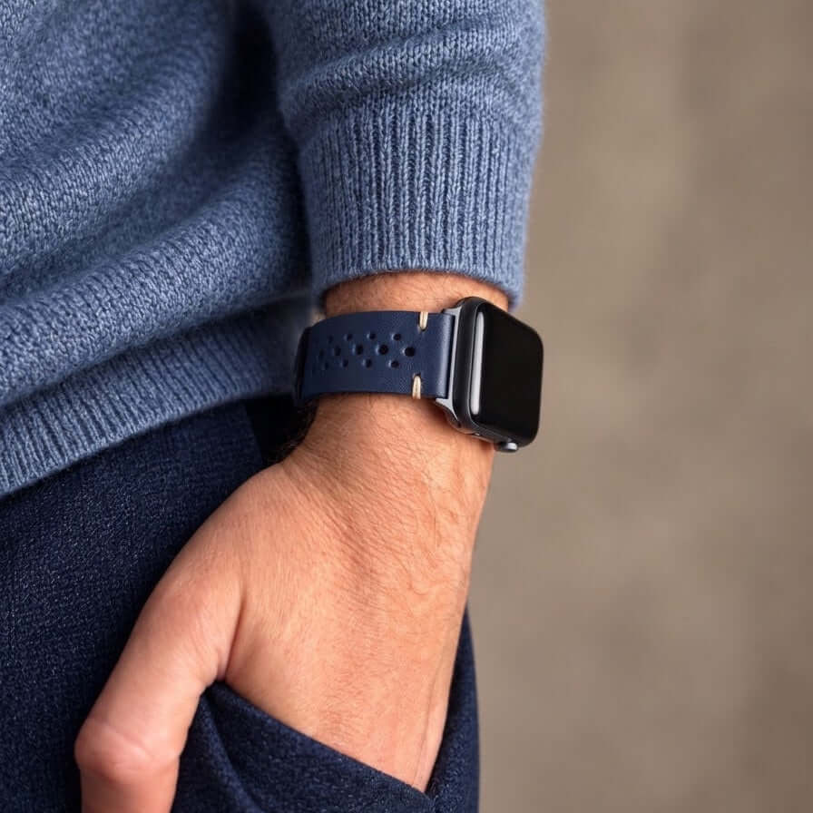 Rallye Lederband für Apple Watch – Blau an einem Handgelenk mit blauer Strickjacke.