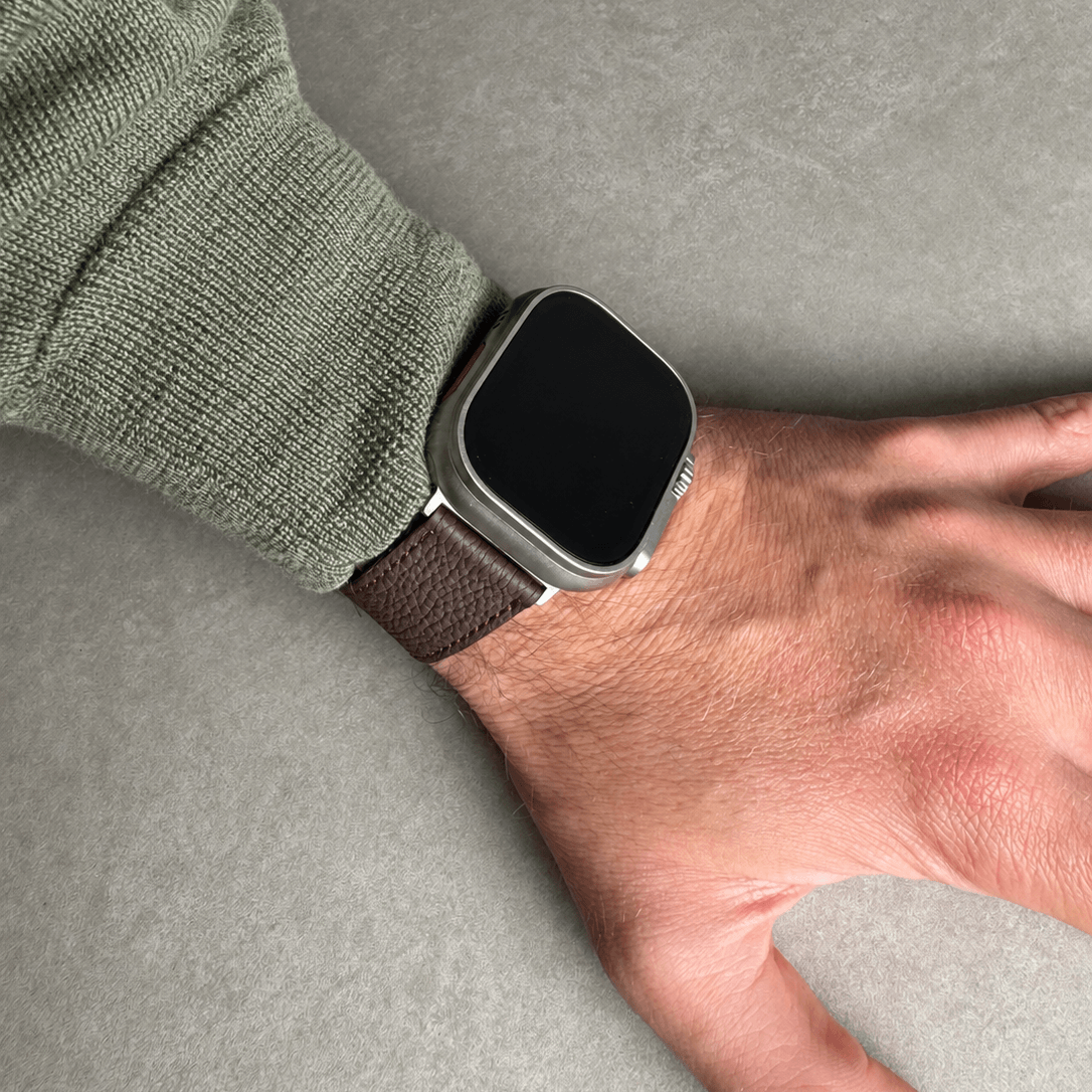 Dunkelbraunes Lederarmband für Apple Watch aus Togoleder, stilvoll getragen am Handgelenk.
