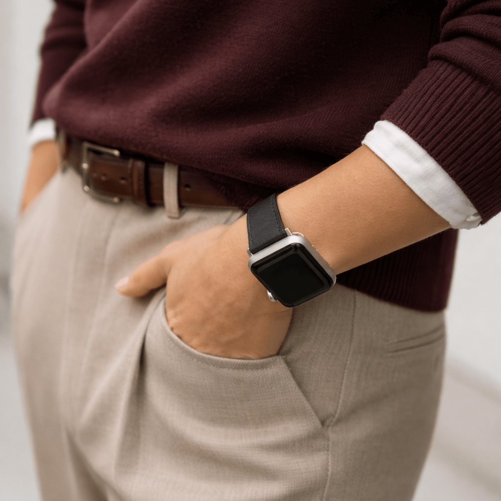 Person mit Schwarzes Apple Watch Armband Leder - Bidart in eleganter Freizeitkleidung, kombiniert mit einem dunklen Pullover.