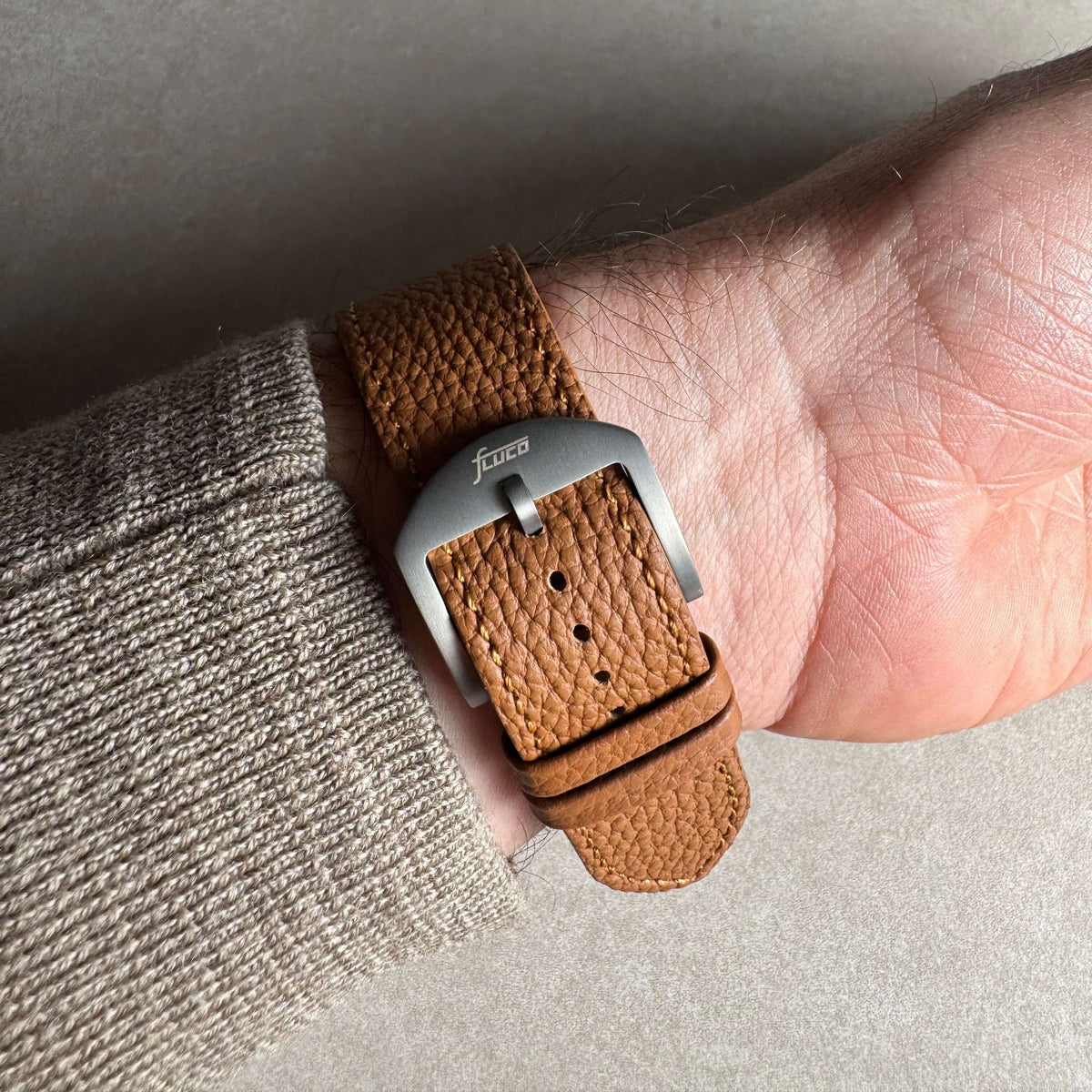 Hellbraunes Lederarmband für Apple Watch aus Togoleder an einem Handgelenk, stilvolles Luxusdesign.