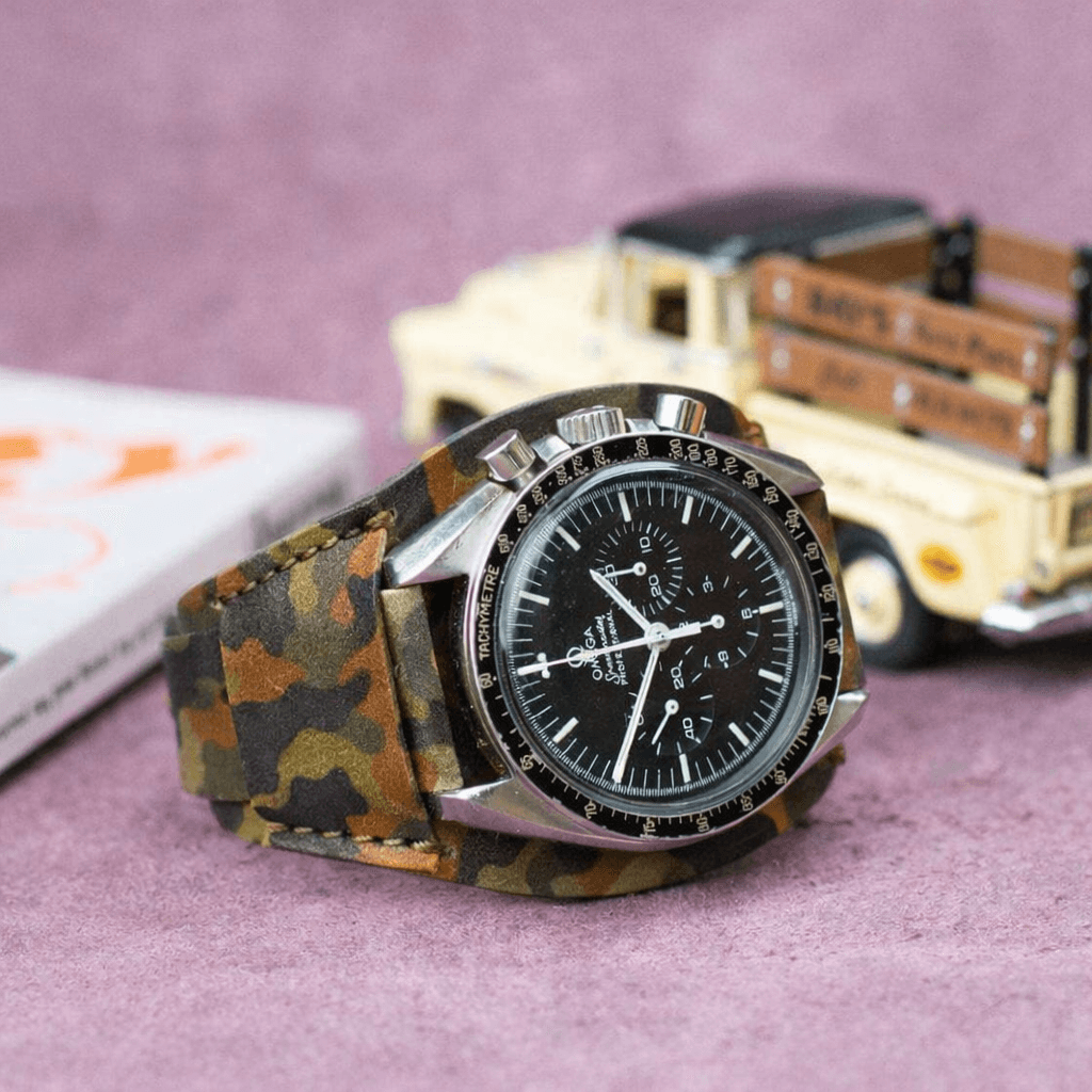 Heritage – Unterlagenband im Camouflage Look mit Armbanduhr, aus vegetabil gegerbtem Rindleder, stilvoll auf Untergrund platziert