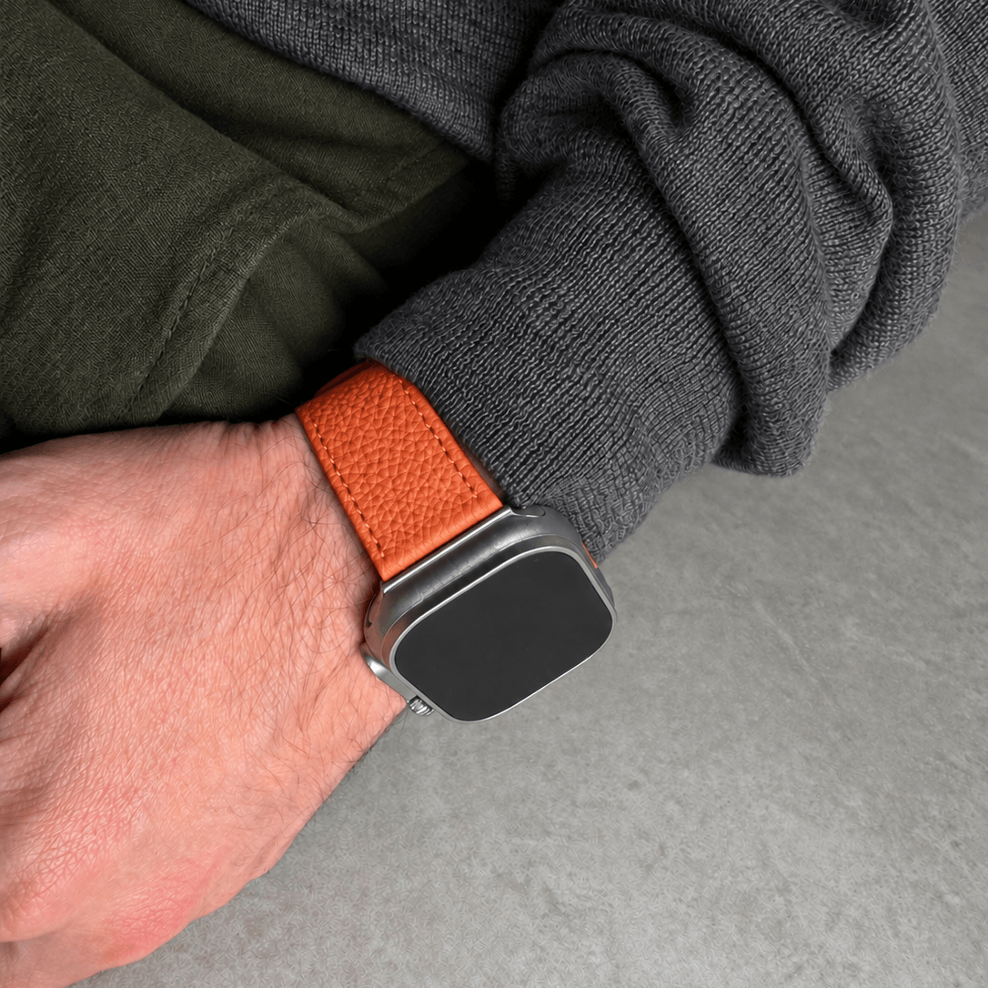Oranges Lederarmband für Apple Watch aus Togoleder, luxuriöses Armband an einem Handgelenk.