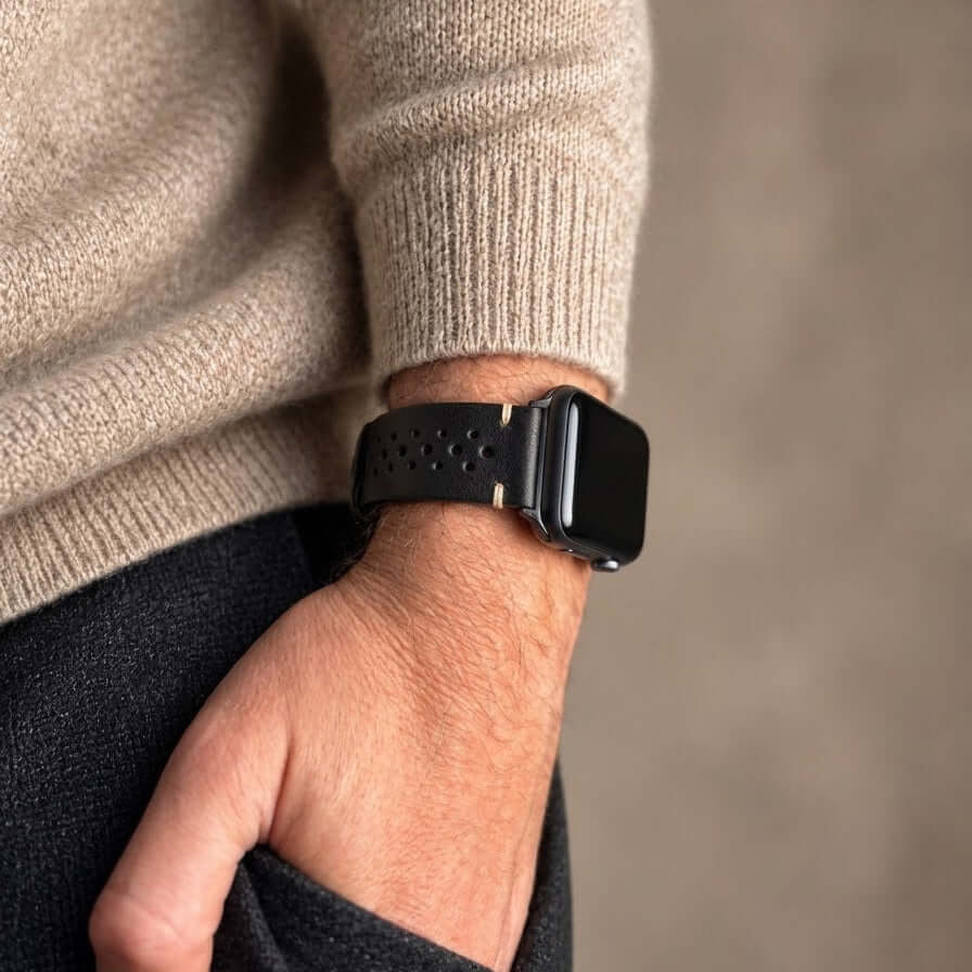 Rallye Lederband für Apple Watch - Schwarz am Handgelenk eines Mannes in gemütlichem Pullover.