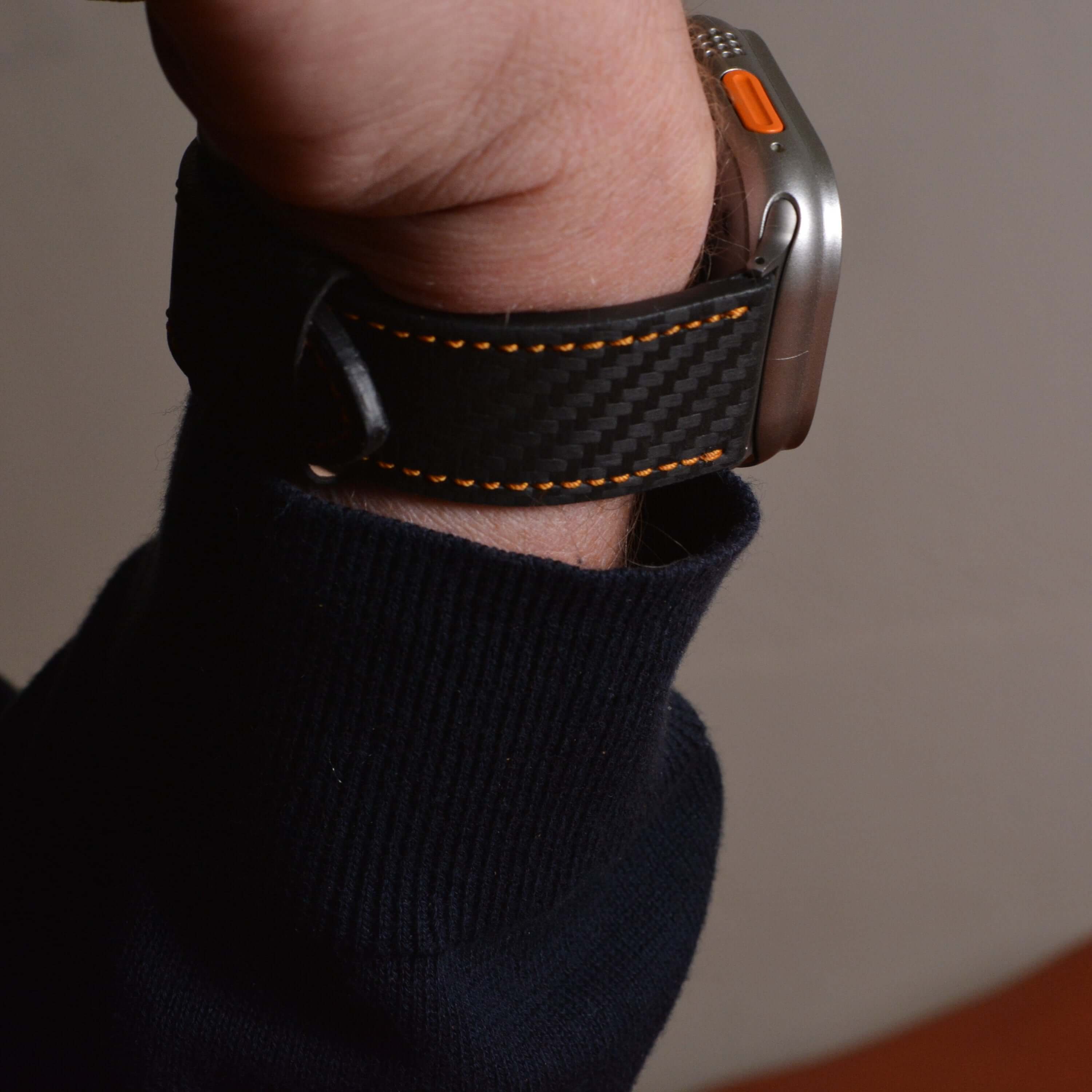 Bergwerk Carbon Orange – Apple Watch Band mit hochwertiger LederCarbon-Struktur, am Handgelenk getragen gezeigt.