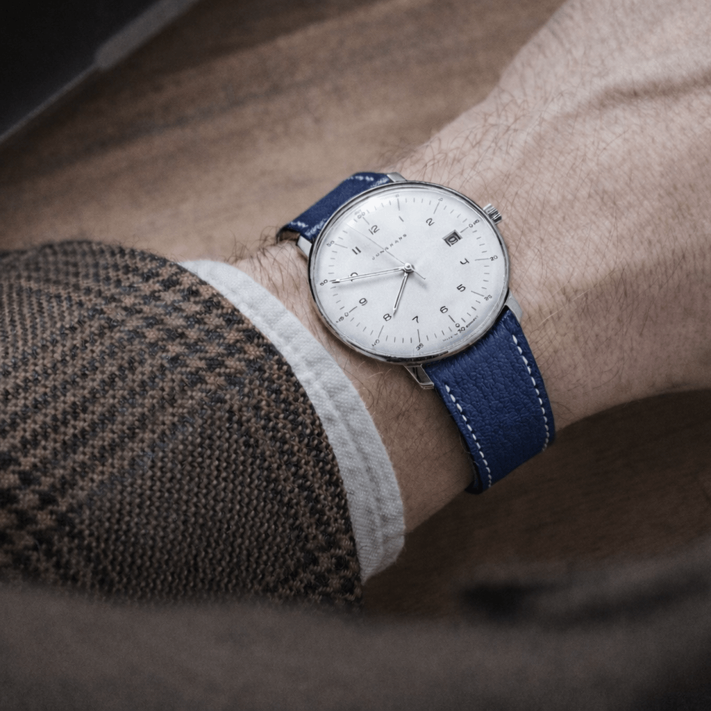 Biarritz – Uhrenarmband aus französischem Ziegenleder in Blau, getragen an einem eleganten Herrenarmband mit weißem Zifferblatt.