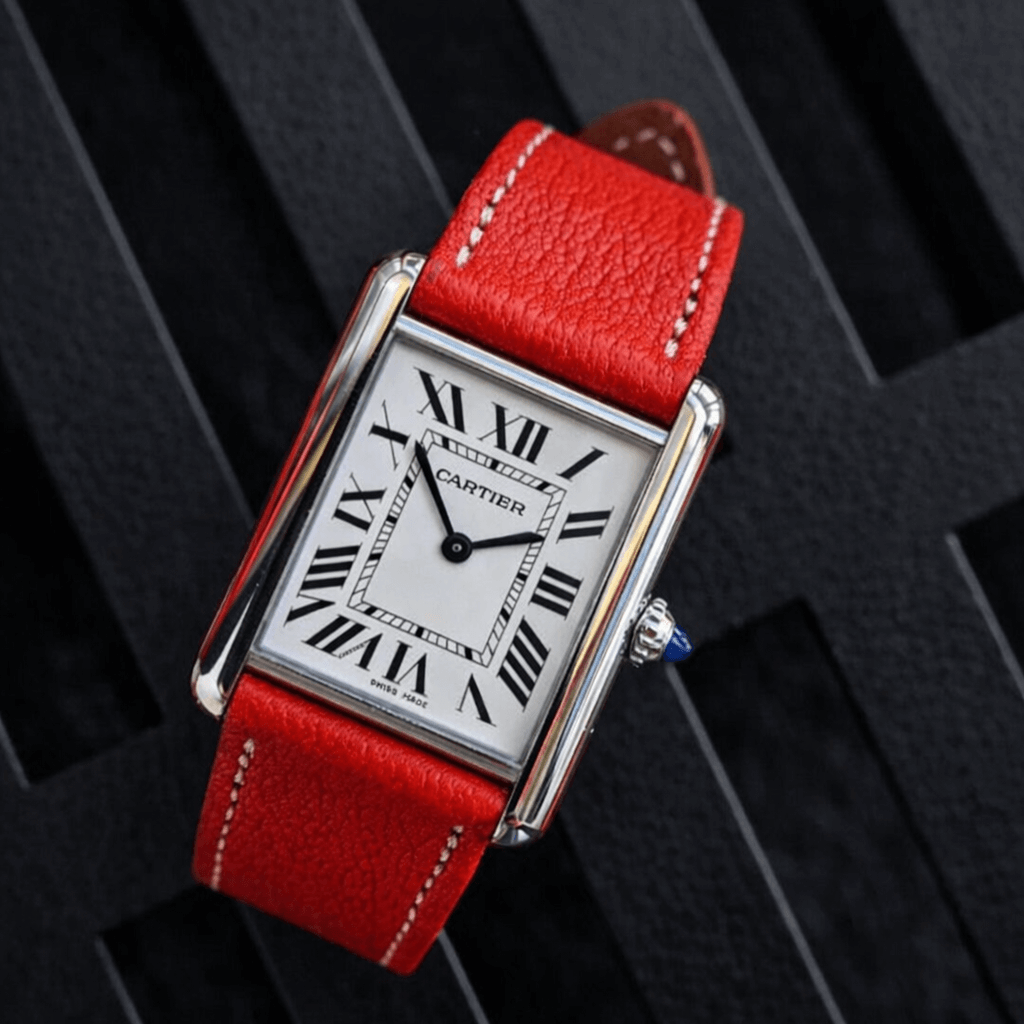 Rote Armbanduhr mit römischen Ziffern und Lederarmband auf schwarzem Hintergrund.