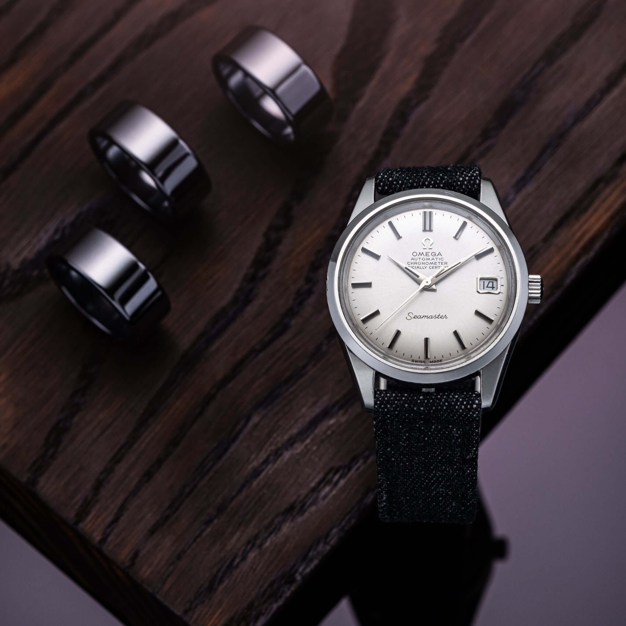 Jeans – Uhrenarmband aus hochwertigem japanischem Denim mit Uhr auf Holztisch und Metallringen, urbaner Stil und Handwerkskunst vereint.