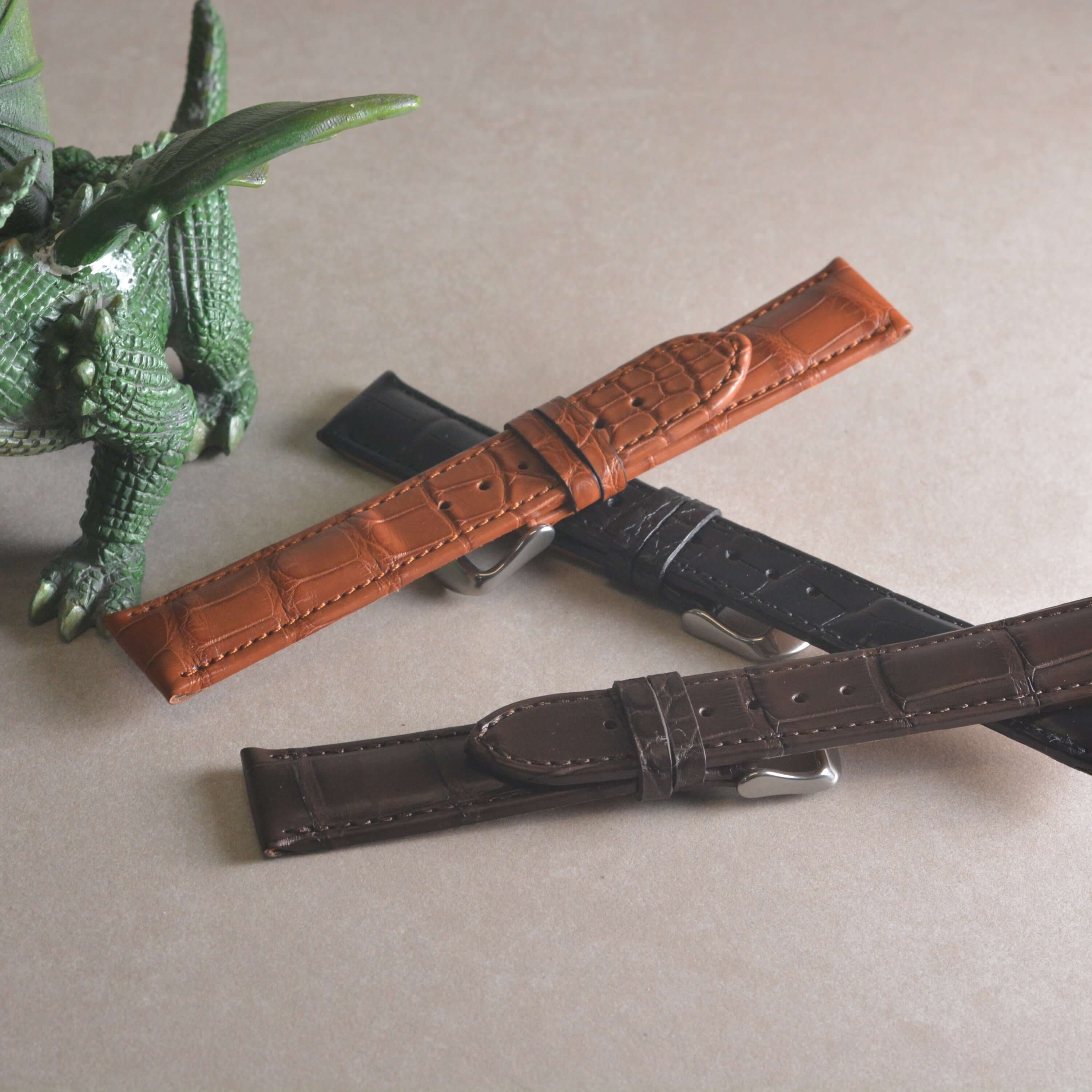 Full Cut bombiert – Armband aus vollflächigem Louisiana-Alligatorleder in verschiedenen Farben neben grünem Zierkrokodil.