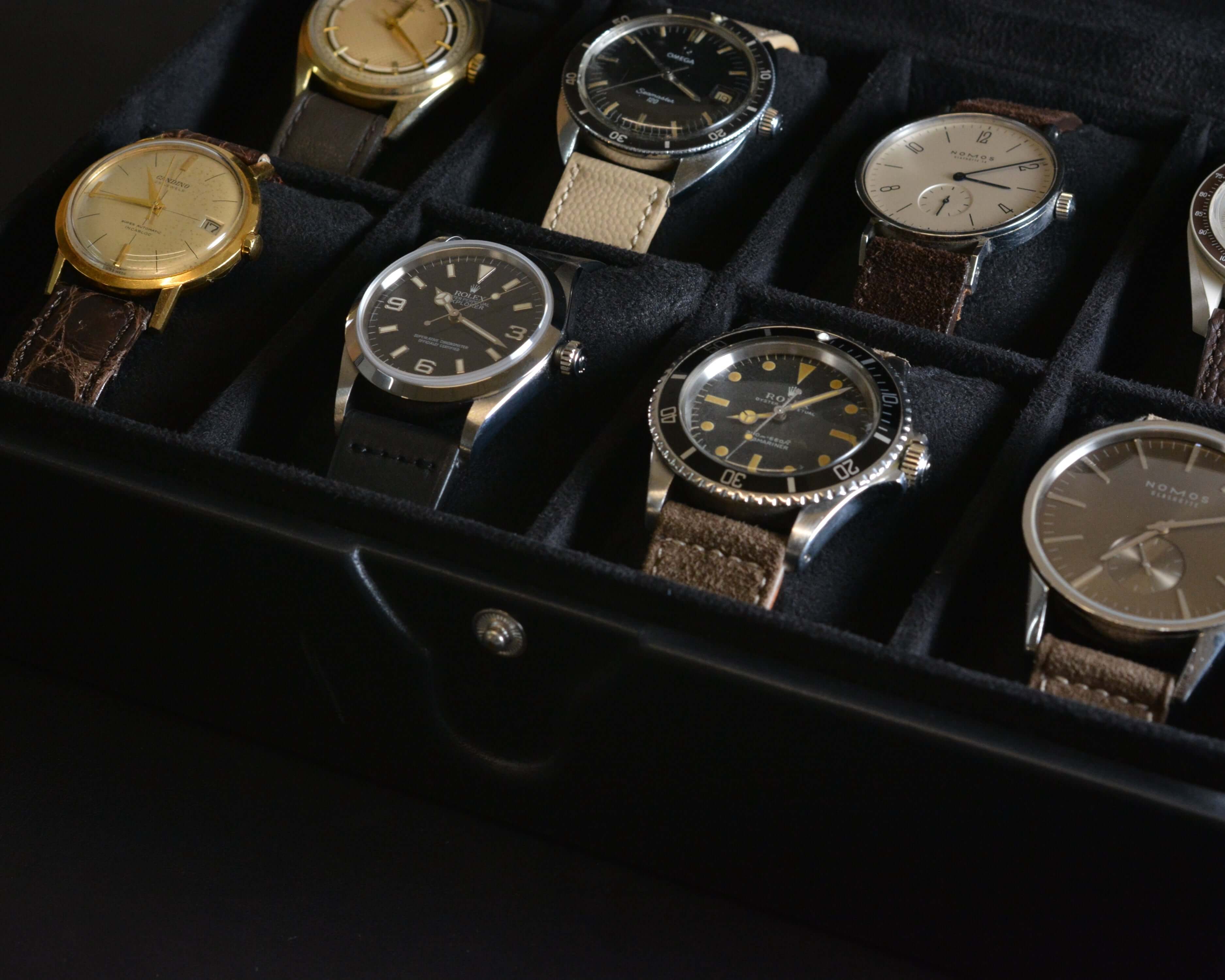 A collection of stylish wristwatches displayed in a black case, showcasing various designs and styles for fashion enthusiasts.