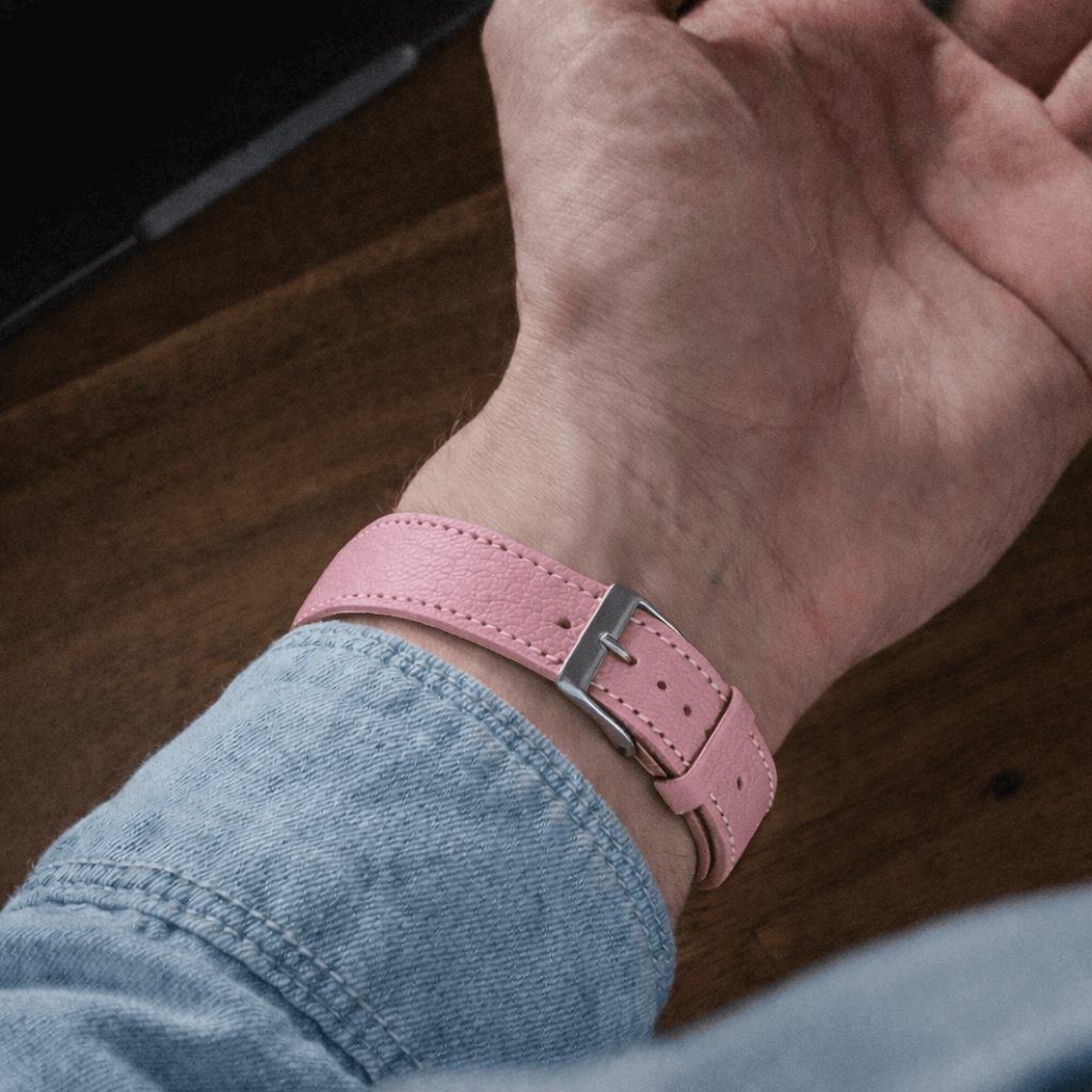 Rosa kurzes Apple Watch Armband- Biarritz am Handgelenk mit hellblauem Hemd hinterlegt.