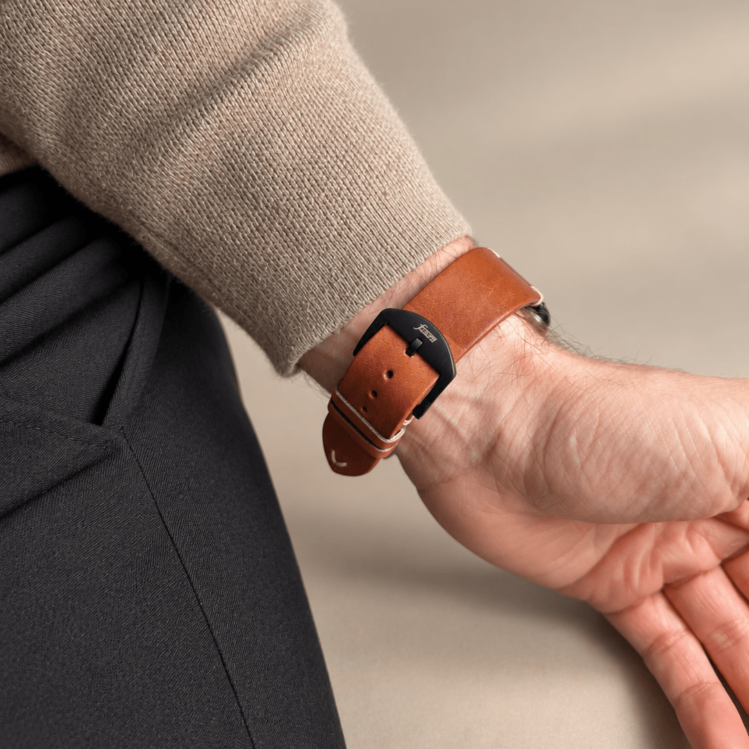 Hunter Apple Watch Armband Leder Hellbraun am Handgelenk, kombiniert mit eleganter Kleidungsstück.