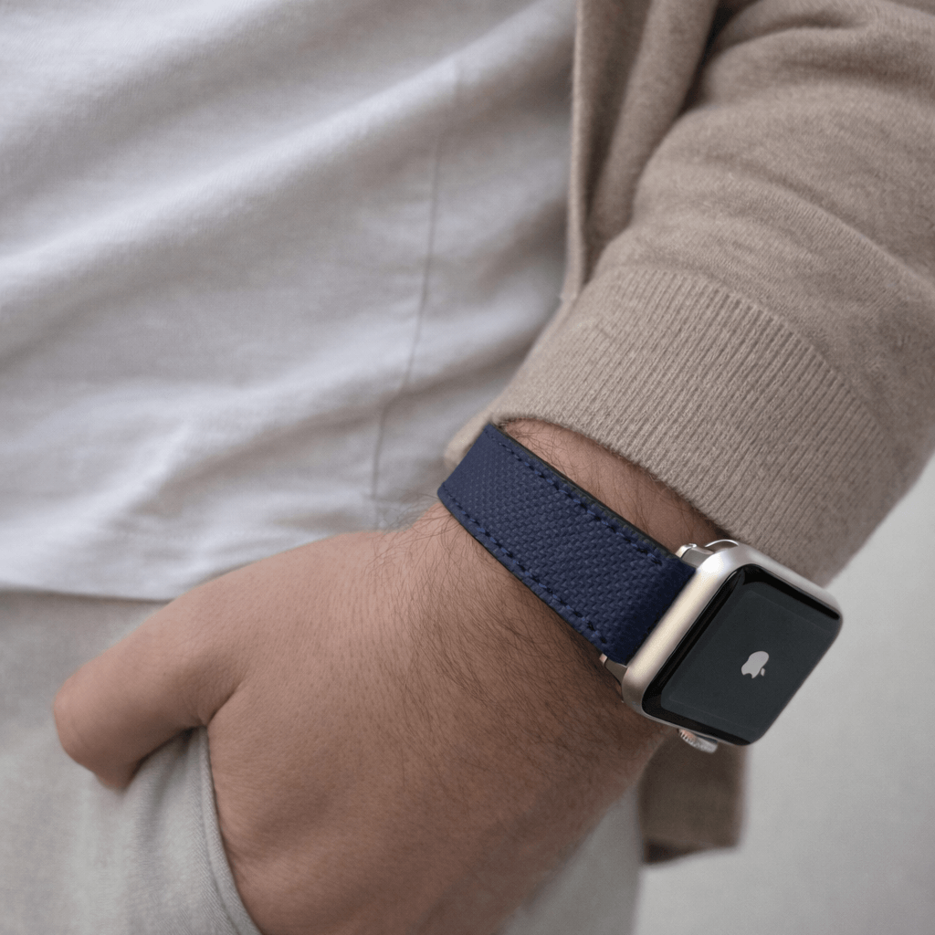 Mann trägt nautisches navyblaues Apple Watch Lederarmband Wasserfest | Nautilus, elegant und robust für den Alltag geeignet.