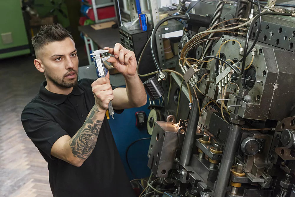 Arbeiter in einer deutschen Uhrenarmband-Manufaktur – Detailaufnahme eines Handwerkers, der mit Präzision und Fokus an einer Uhrenarmband-Schließe arbeitet. Die Szene zeigt die hochwertige Fertigung von Uhrenarmband-Schließen, die ausschließlich in Deutschland produziert werden. Das Bild betont die Handwerkskunst und „Made in Germany“ Qualität der Uhrenarmbänder und -schließen.