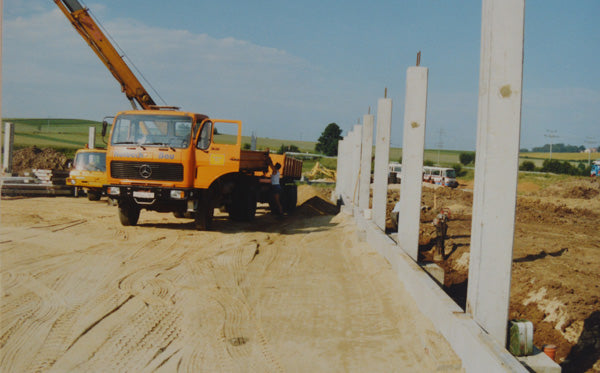 Baubeginn der Fluco Manufaktur in Fürth im Wald im Jahr 1990 – Historisches Bild von der Baustelle zu Beginn der Errichtung der Fluco Fabrik, die für die Produktion hochwertiger Uhrenarmbänder bekannt wurde. Das Bild zeigt das Fundament des Gebäudes und die ersten Bauarbeiten für die Fertigungseinrichtungen.