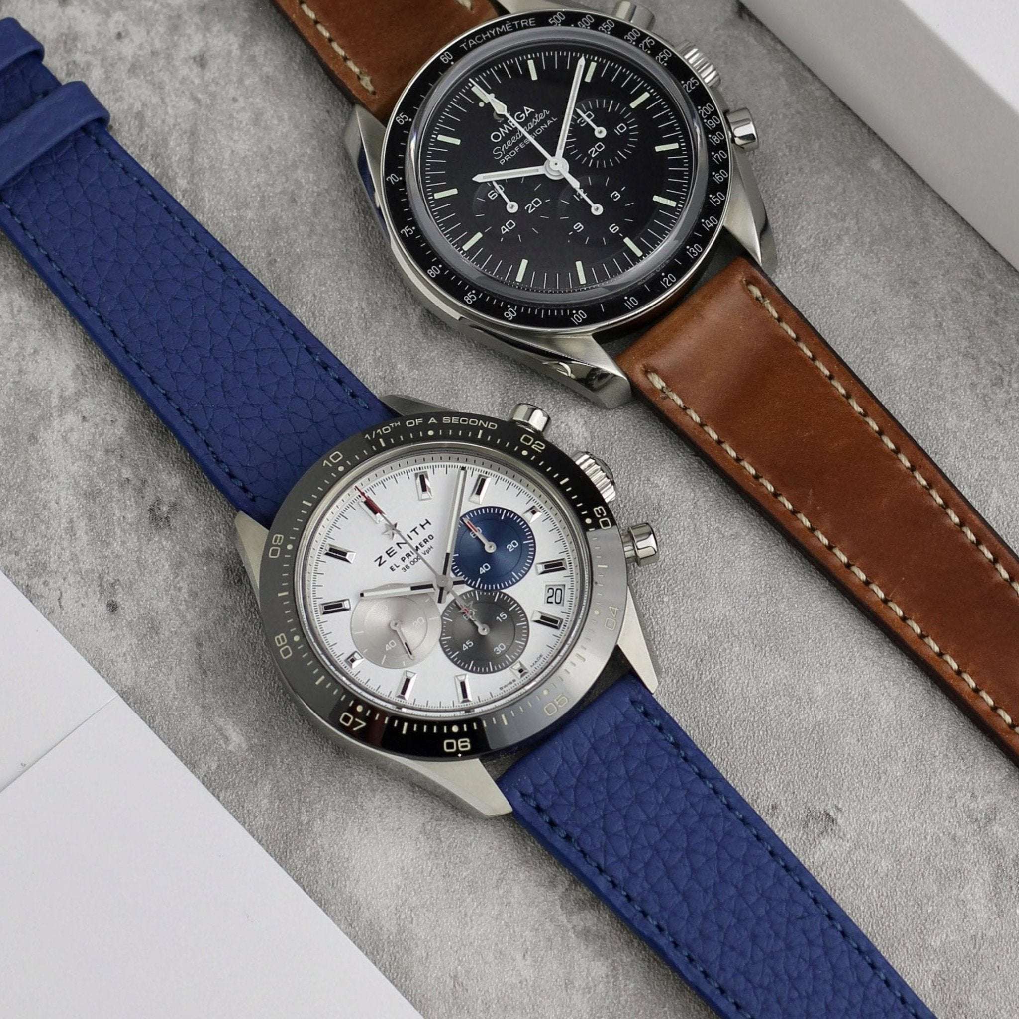 Blaues Deauville Uhrenarmband aus Fjordleder an Zenith El Primero, daneben Whisky-Cordovan-Armband an Omega Speedmaster