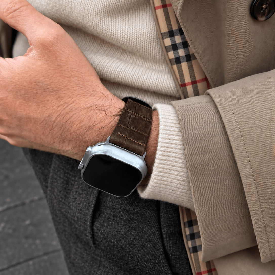 Dakkar Dunkelbraun – 24 mm Apple Watch Ultra Lederarmband in Kroko-Optik am Handgelenk eines Mannes.