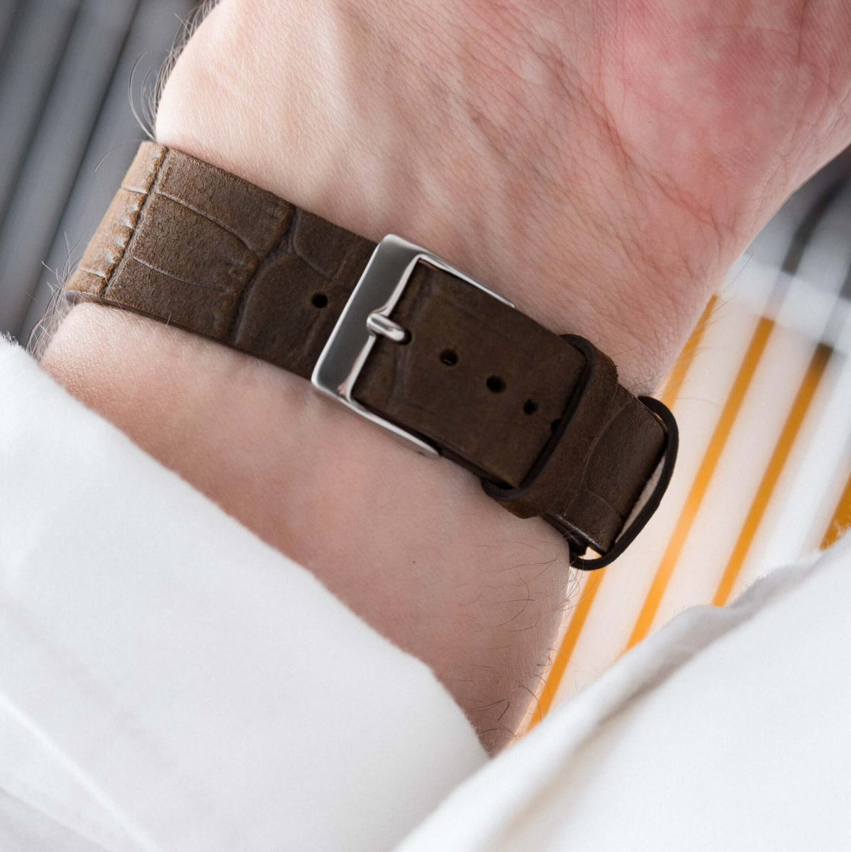 Dakkar – Uhrenarmband aus italienischem Nubukleder mit Krokoprägung in Dunkelbraun am Handgelenk.