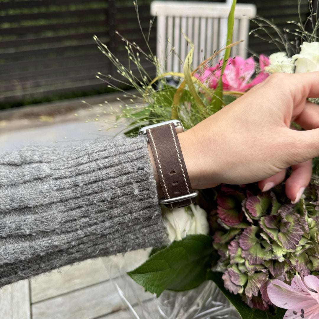 Nahaufnahme eines Handgelenks mit einem grauen Apple Watch Lederarmband Vintage, das für 44mm und 45mm Apple Watch Modelle geeignet ist.