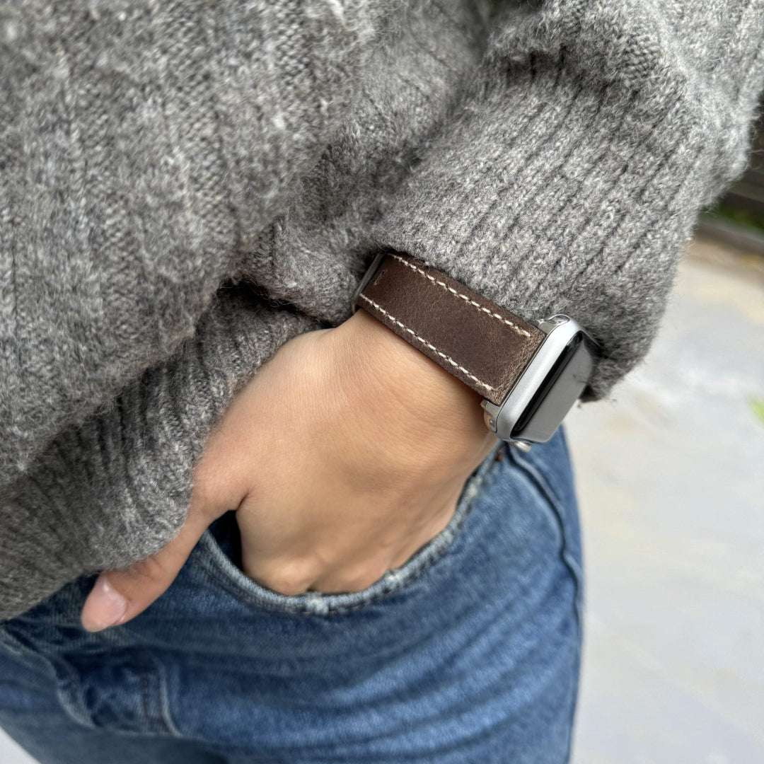 Das Apple Watch Lederarmband Vintage in grauer Farbe, ideal für 42mm und 44mm Modelle, sieht perfekt aus am Handgelenk einer Person.