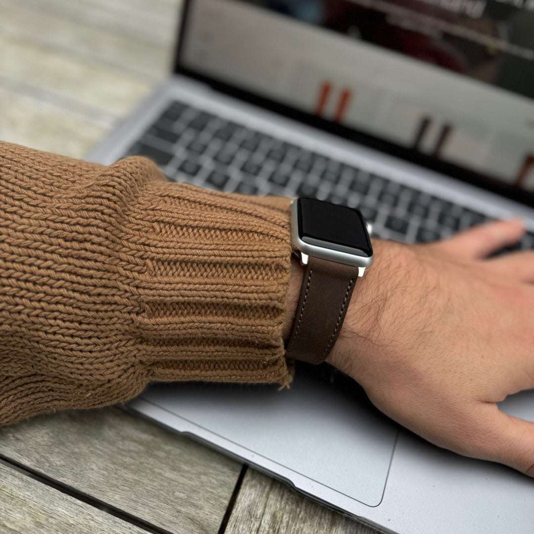 Dunkelbraunes Nubukleder-Armband für Apple Watch am Handgelenk – Frontansicht mit braunem Pullover