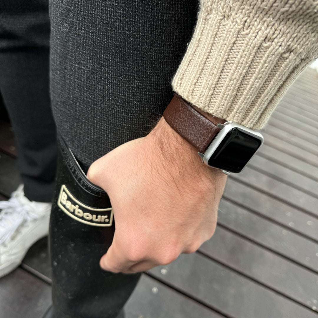 Dunkelbraunes veganes Weinleder-Armband für Apple Watch – Elegantes pflanzliches Lederarmband mit Gummistiefeln im Hintergrund, Frontansicht