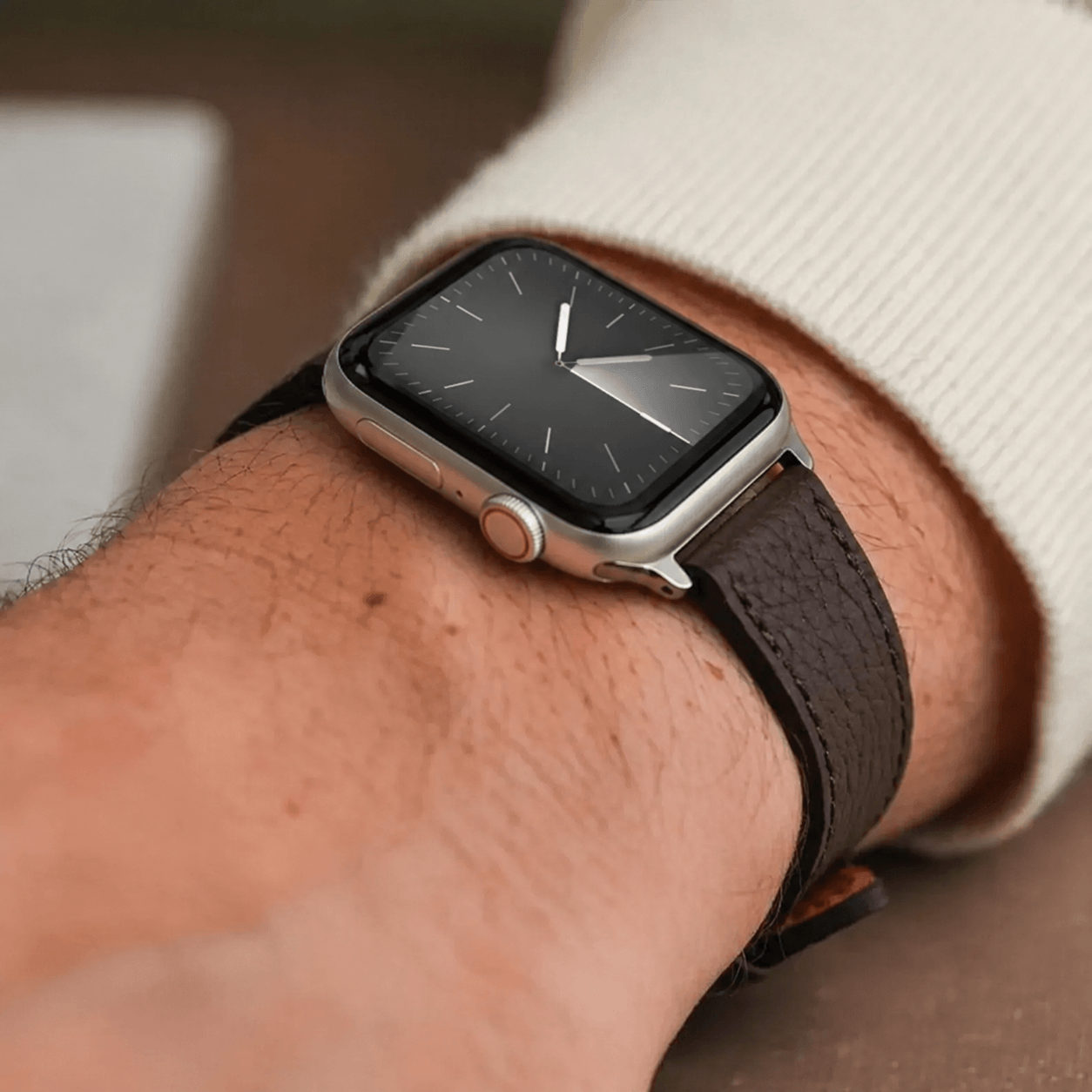 Dunkelbraunes Lederarmband für Apple Watch aus Togoleder an einem Handgelenk mit Uhr.