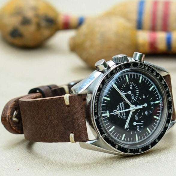 Dunkelbraunes Uhrenarmband aus hochwertigem vegetabil gegerbtem Rindleder an Omega Speedmaster – Detailaufnahme der Omega Speedmaster Uhr mit hochwertigem dunkelbraunem Uhrenarmband, das für seine Langlebigkeit und luxuriöse Ausstrahlung bekannt ist