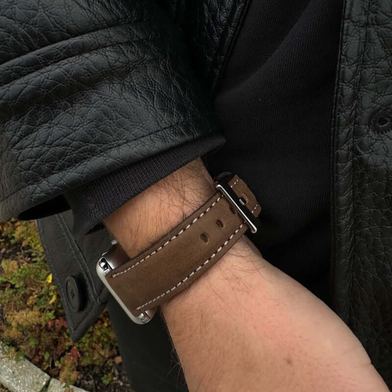 Apple Watch 8 Armband Leder in Dunkelbraun, das an einem Handgelenk getragen wird.